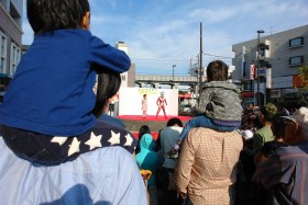 お父さんに肩車されてウルトラマンタロウを見る子ども